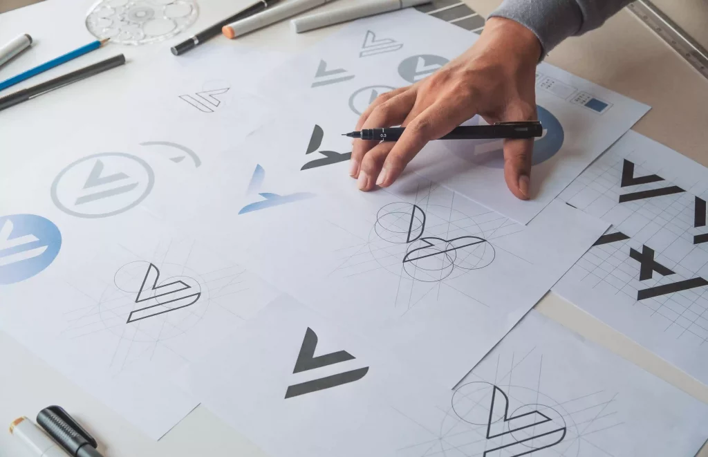 Esquisse manuelle d'un logo sur papier, illustrant le processus de création en direction artistique