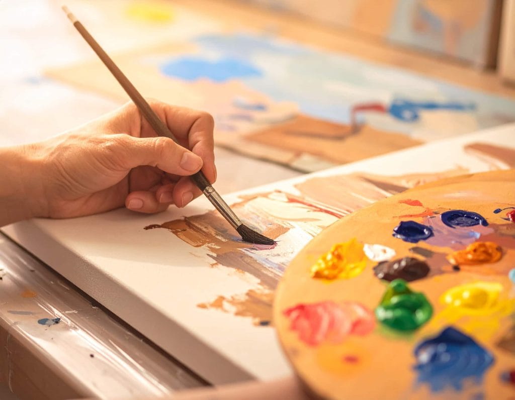 Gros plan sur des mains d’artiste peignant une toile