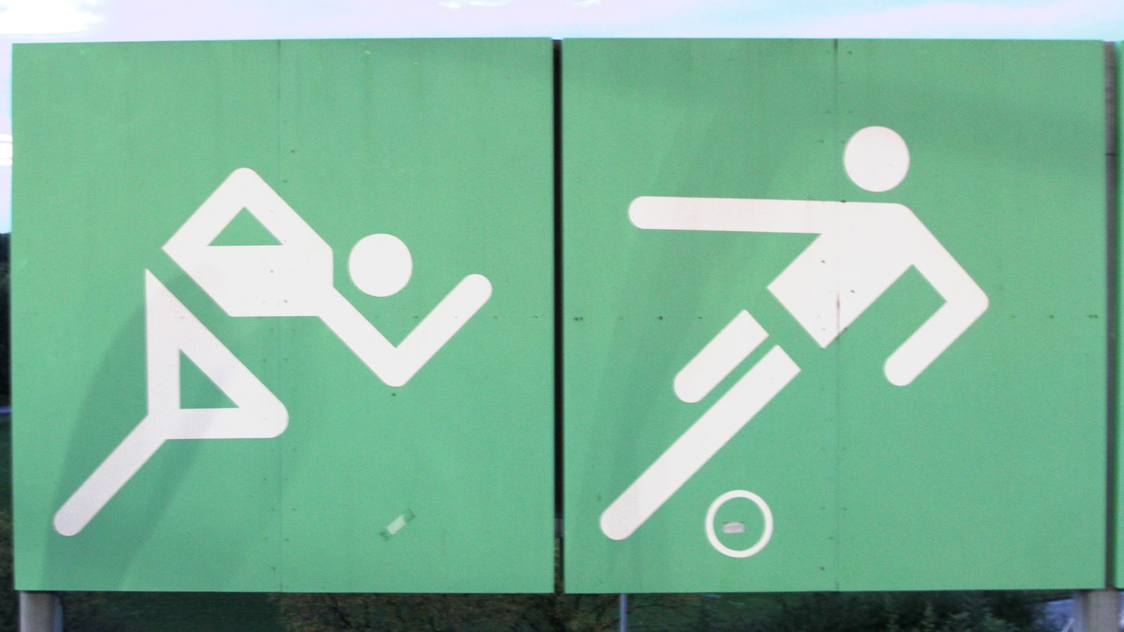 Panneaux verts présentant les pictogrammes d’athlétisme et de football de Munich 1972 à la station olympique